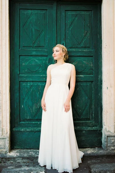 Novia Vestido Blanco Apoya Apoyada Una Puerta Verde Foto Alta —  Fotos de Stock