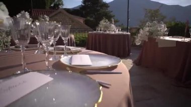 Davetiyeler, taş bir evin avlusundaki sofraların üzerinde duruyor. Yüksek kaliteli FullHD görüntüler