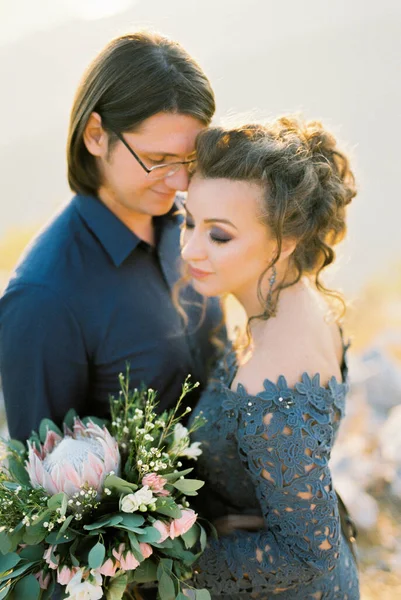 Groom Étreint Mariée Dans Une Robe Dentelle Bleue Avec Bouquet — Photo