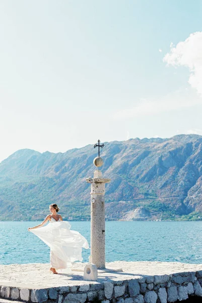 Gelin Elbisenin Dalgalı Kenarını Iskelede Tutuyor Yüksek Kalite Fotoğraf — Stok fotoğraf