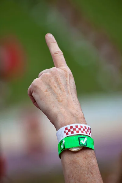 Person pointing the number one finger at a sporting event.