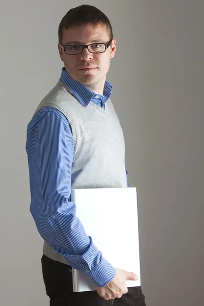 Gelukkig man in blauw shirt en zwarte glazen met laptop. — Stockfoto