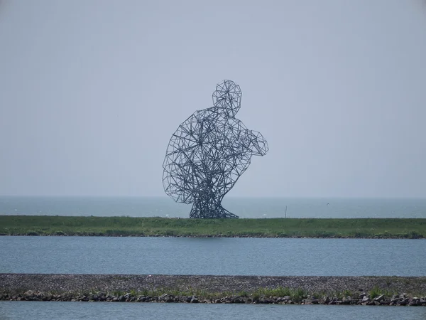 Exposure statue of a squatted man — Stock Photo, Image