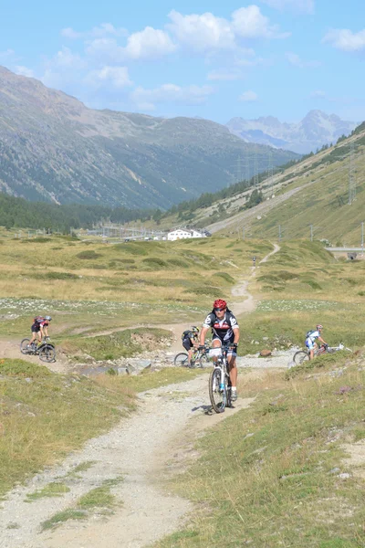 Mountain bikers riding though Swiss mountain area — Stock Photo, Image