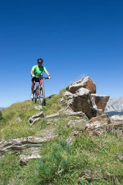 Ciclista de montaña en descenso en los Alpes suizos — Foto de Stock