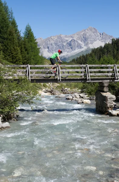 Mountain biker przekraczających most — Zdjęcie stockowe