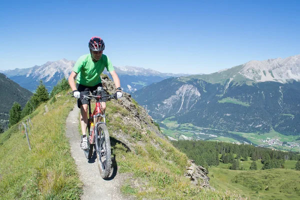 Mountainbiker rijden bergafwaarts in Zwitserse Alpen — Stockfoto