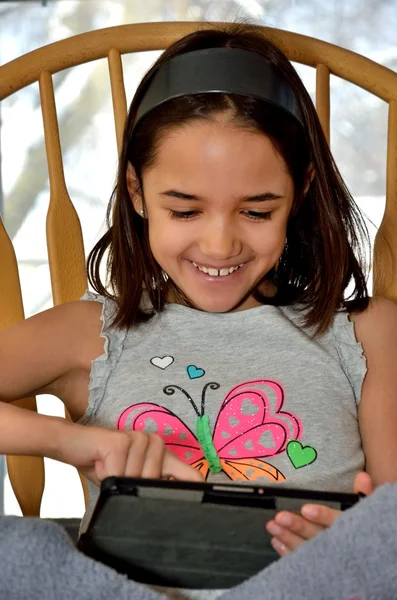 Pequena menina hispânica com um tablet — Fotografia de Stock