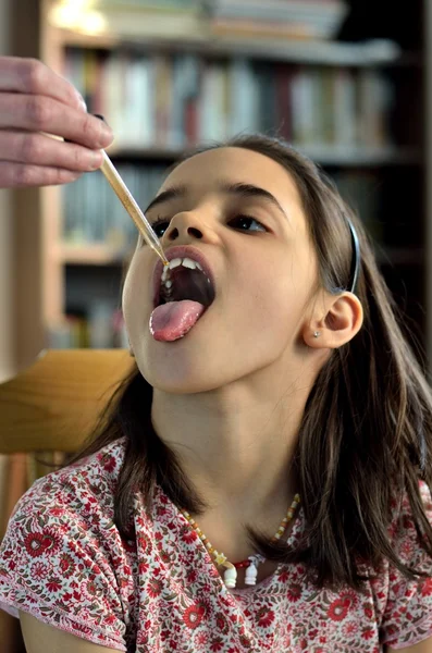 LIttle girl takes a drop of medicine — Stock Photo, Image