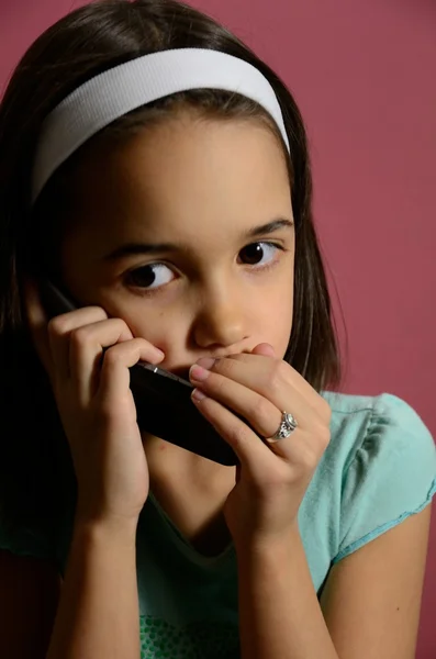 Klein meisje geheimen vertellen op de telefoon — Stockfoto