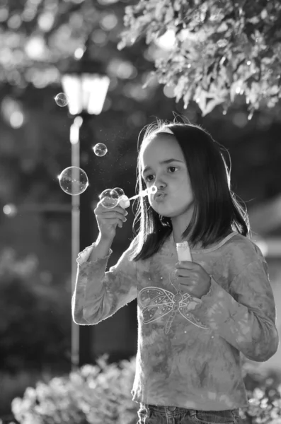 Pequeña chica hispana soplando burbujas —  Fotos de Stock