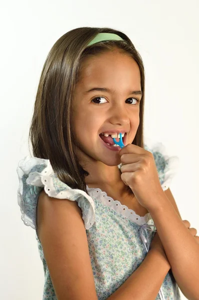 Kleines hispanisches Mädchen mit Zahnseide Stockfoto