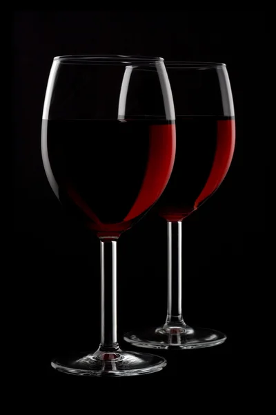 Twee glazen van rode wijn geïsoleerd op zwarte achtergrond — Stockfoto