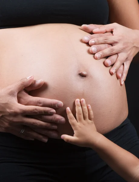 Family hands touching pregnant belly — Stock Photo, Image