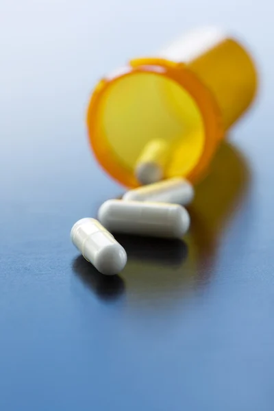 Capsules spilled from pill bottle — Stock Photo, Image