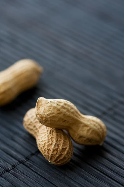 Peanuts on black, close-up — Stock Photo, Image