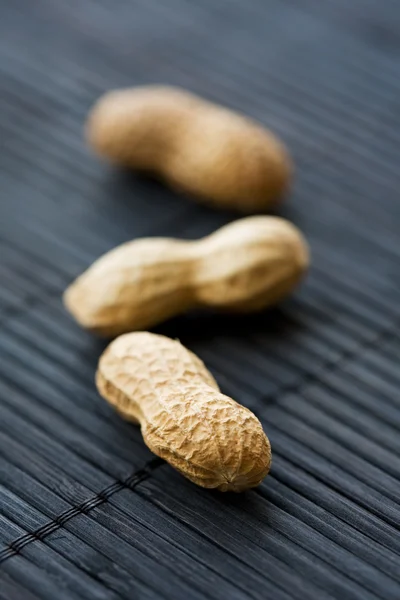 Peanuts on black, close-up — Stock Photo, Image