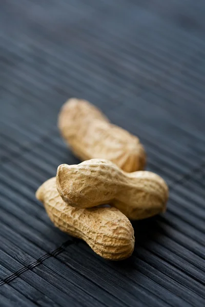 Amendoins em preto, close-up — Fotografia de Stock