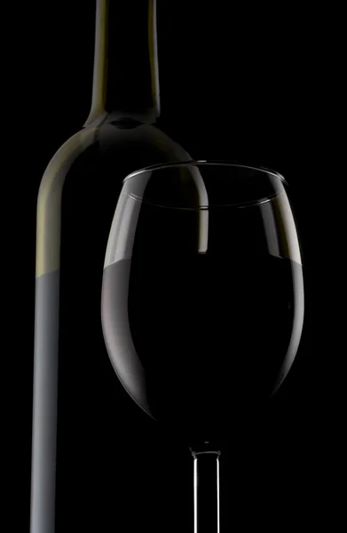 One glass and bottle of red wine isolated on black background — Stock Photo, Image