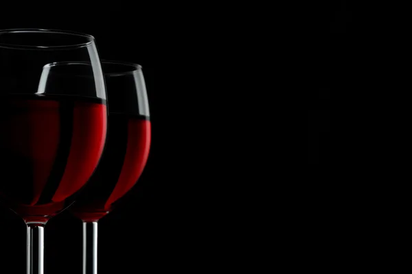 Two glassed of red wine isolated on black background — Stock Photo, Image