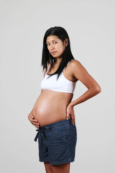 Pregnant Peruvian woman, posing, touching her belly — Stock Photo, Image