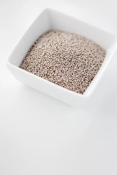 Sementes de chia branca em uma tigela contra fundo branco — Fotografia de Stock