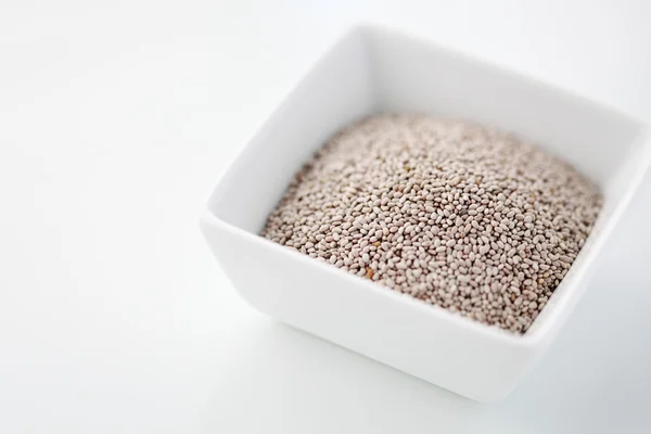 White chia seeds in a bowl against white background — Stock fotografie