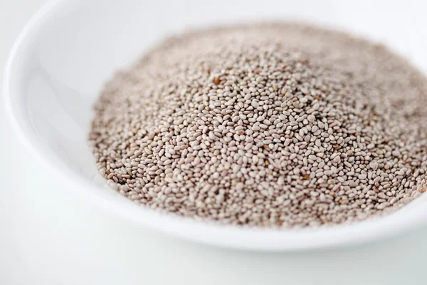 White chia seeds in a bowl against white background — Stock fotografie