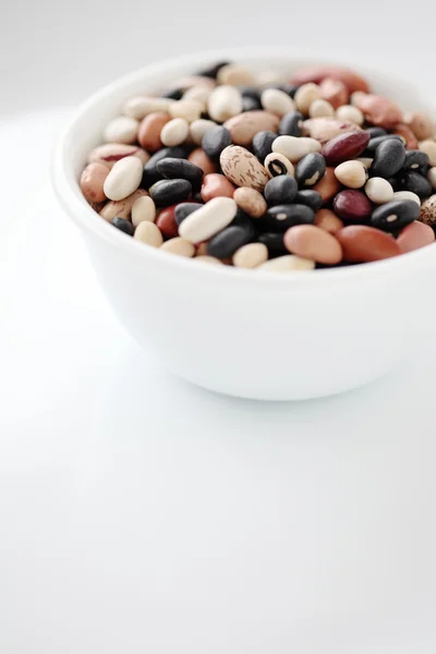 Variedad de frijoles secos en un tazón aislado sobre fondo blanco —  Fotos de Stock