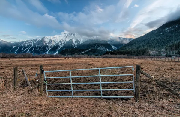 Puerta de valla con montañas nevadas —  Fotos de Stock