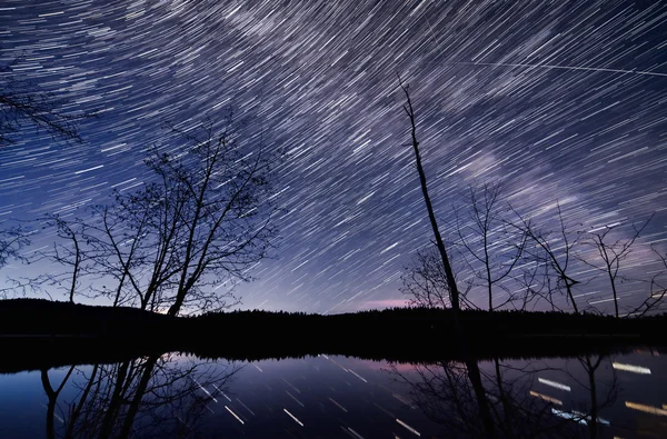 Muitas trilhas estelares no céu noturno azul escuro — Fotografia de Stock