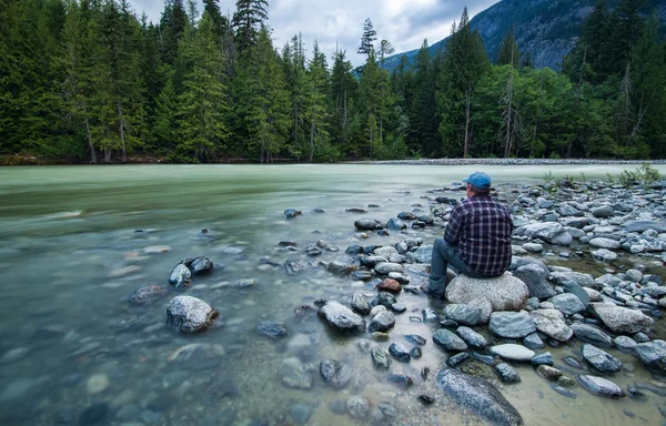 Man Sitting Beside River Paisagem — Fotografia de Stock