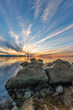 Phipps Point, Hornby Adası, British Columbia, Kanada 'daki kayaların ardında güzel bir günbatımı.
