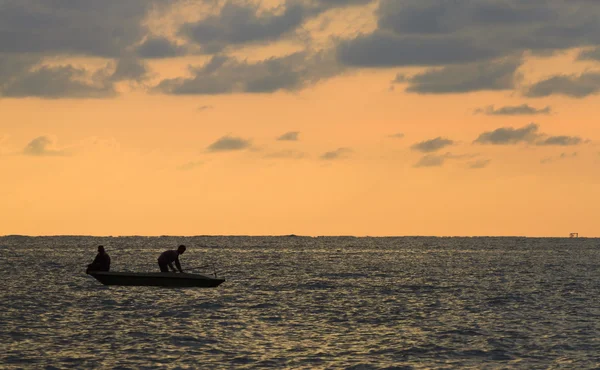 Silhouette von Männern, die im Meer fischen — Stockfoto