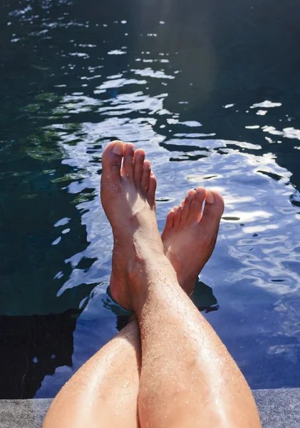 Gambe rilassanti accanto a una piscina — Foto Stock