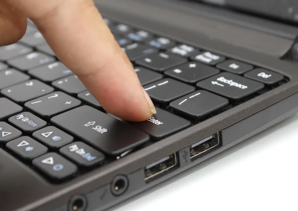 Palcem naciskając klawisz enter na klawiaturze laptopa — Zdjęcie stockowe