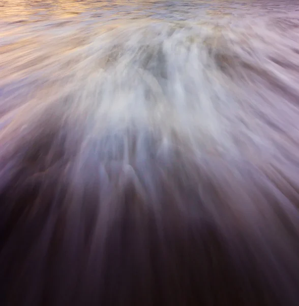 日没で劇的な流れる波 — ストック写真