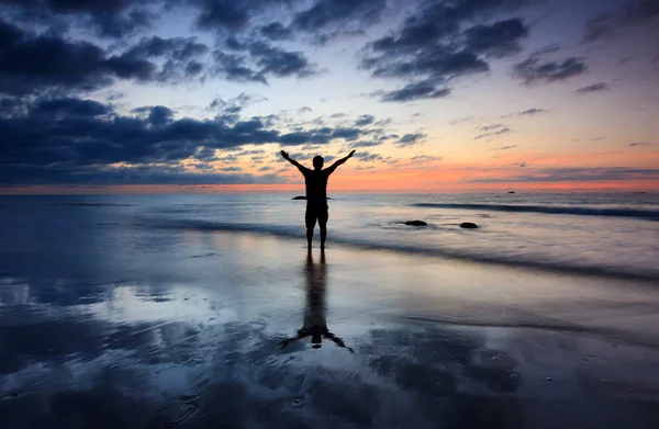 Silhueta de um homem com dramática reflexão do pôr do sol — Fotografia de Stock