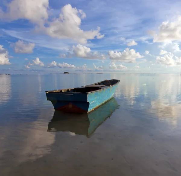 Barco solitario en el mar con reflejo del cielo azul —  Fotos de Stock