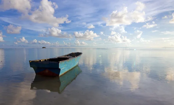Eenzame boot op zee met reflectie van de blauwe hemel — Stockfoto