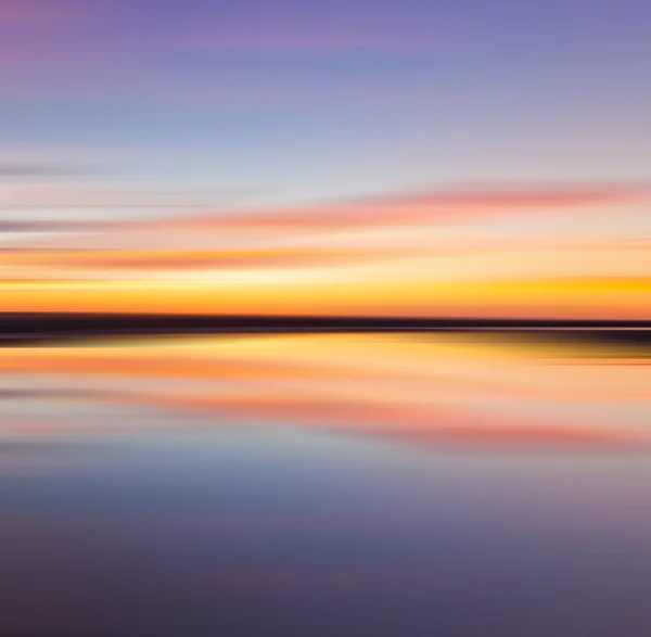 Weerspiegeling van kleurrijke zonsondergang met lange blootstelling ingang, beweging wazig — Stockfoto