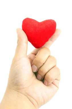 küçük kalp şeklinde yastık üzerinde beyaz izole tutmak el