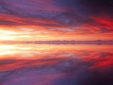Reflection of dramatic and colorful clouds clipart