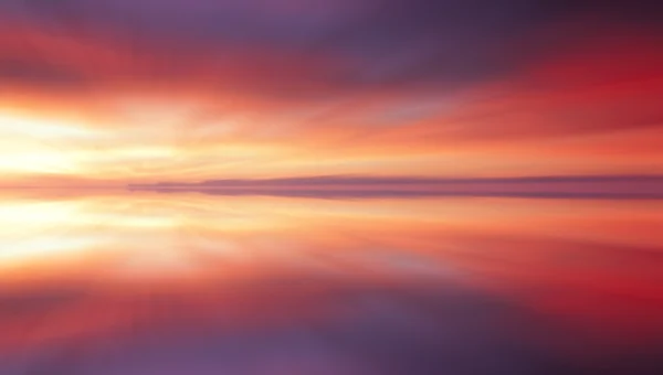 Reflection of colorful sunset clouds with long exposure effect, zoom blurred — Stock Photo, Image