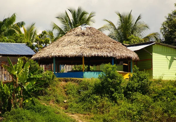 Hus på styltor stiga över det förorenade vattnet i islandia peru — Stockfoto