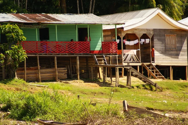 Hus på styltor stiga över det förorenade vattnet i islandia peru — Stockfoto