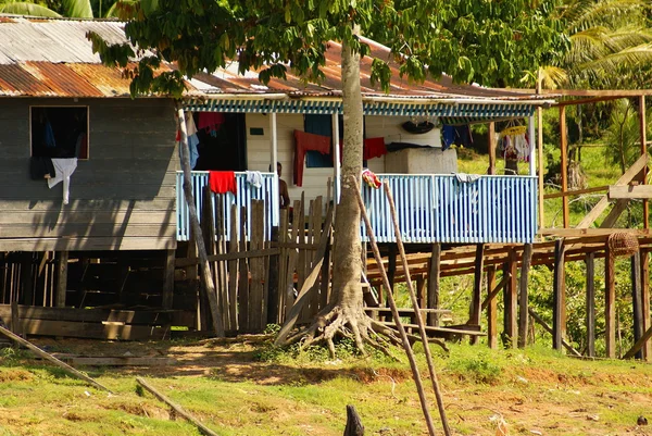 Casas em palafitas elevam-se acima da água poluída em Islandia Peru — Fotografia de Stock