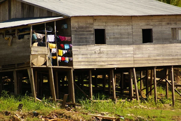 Casas em palafitas elevam-se acima da água poluída em Islandia Peru — Fotografia de Stock