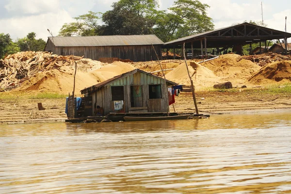 Häuser auf Stelzen ragen über das verschmutzte Wasser in Inselperu — Stockfoto