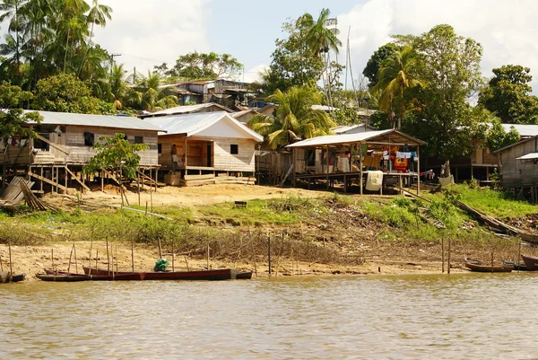 Häuser auf Stelzen ragen über das verschmutzte Wasser in Inselperu — Stockfoto